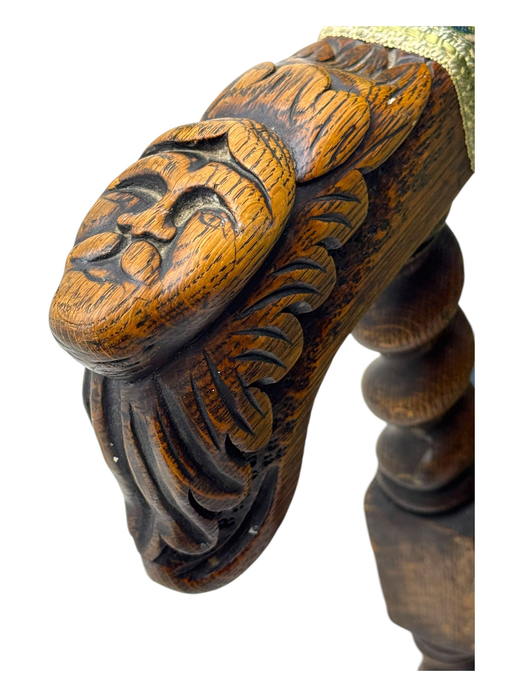 19th century Carolean design oak armchair, upholstered in a vibrant fabric depicting woodland and wildlife scenes, carved lion mask arm terminals, raised on barley twist supports united by H-stretcher