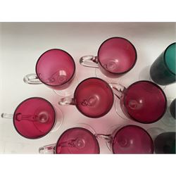 Collection of 19th century coloured glasses, to include nine cranberry glass punch cups, each with clear glass handle and foot and a set of six green glasses, with short clear stems, tallest H10cm