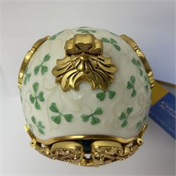 Franklin Mint The Emerald Isle Collector Egg, the egg decorated with embossed shamrocks upon a cream ground, with a gilded shamrock finial, accents and openwork door, opening to reveal a miniature landscape scene, upon three gilded feet set with green paste stones, with certificate of authenticity H23cm, 
