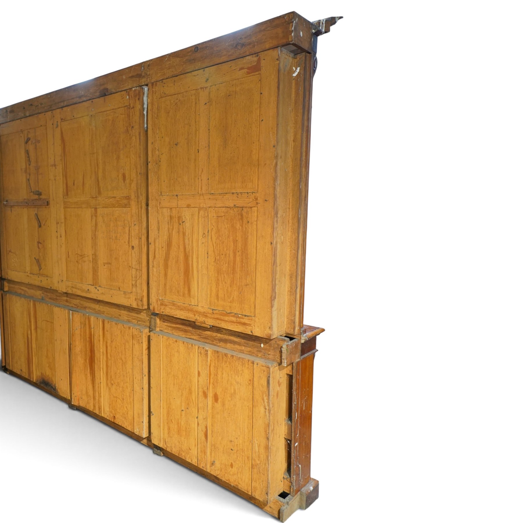 Large early 19th century Country House mahogany breakfront library bookcase, the projecting moulded cornice over a frieze applied with carved flowerhead paterae, the open panelled upper section fitted with adjustable shelves and shaped valances, divided by moulded pilasters with acanthus-carved corbels, the projecting base enclosed by eight panelled cupboard doors with central turned canted pilaster, on plinth base