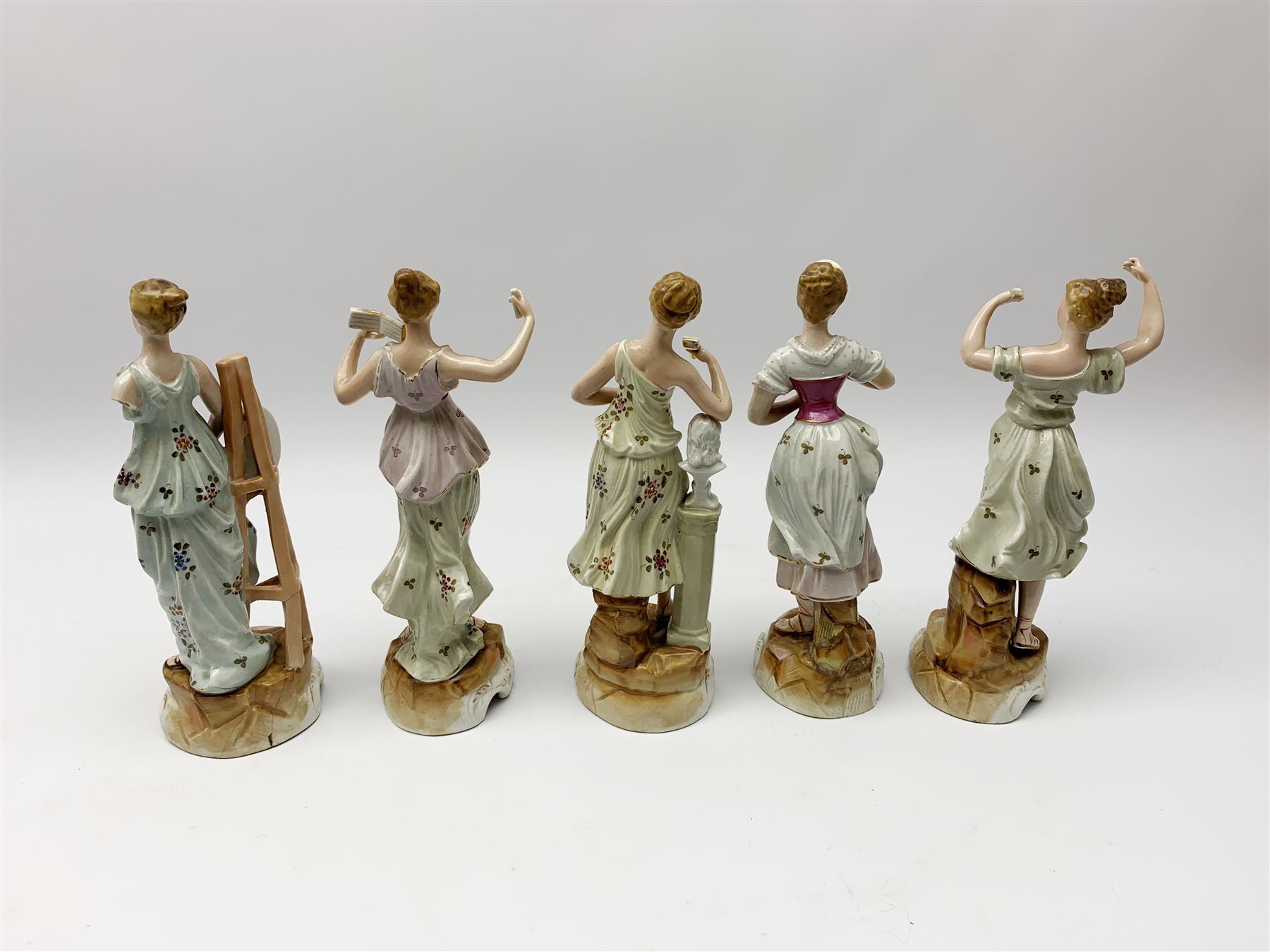 A group of five Continental figurines modelled as the arts, emblematic of music, painting, sculpture, literature, and theatre, each with spurious blue cross mark beneath, H22.5cm. (5). 