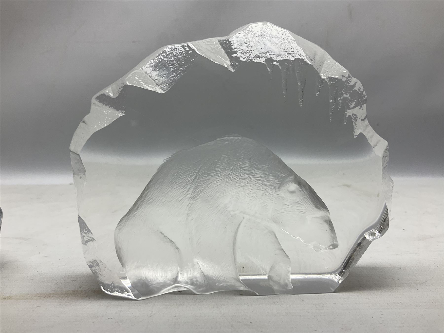 Two Mats Jonasson, Sweden paperweights, comprising polar bear in ice cave no 3152 and lion cubs, both with etched marks beneath, tallest H11.5cm