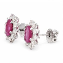 Pair of 18ct white gold ruby and diamond earrings, each stud set with a single oval cut ruby and surrounded by ten round brilliant cut diamonds, stamped, total ruby weight approx 1.40 carat, total diamond weight approx 0.60 carat