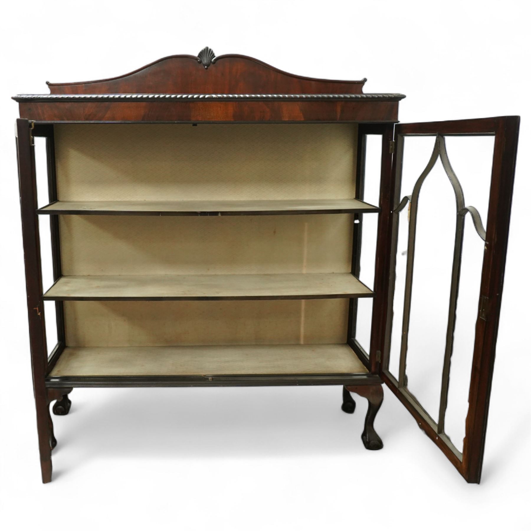 Early 20th century mahogany display cabinet, shaped pediment over a dentil moulded cornice, twin astragal glazed doors enclosing three shelves, raised on cabriole supports with pad feet
