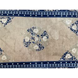 Chinese washed woollen peach ground rug, indigo borders and trailing foliate decoration, central medallion decorated with flowerheads 
