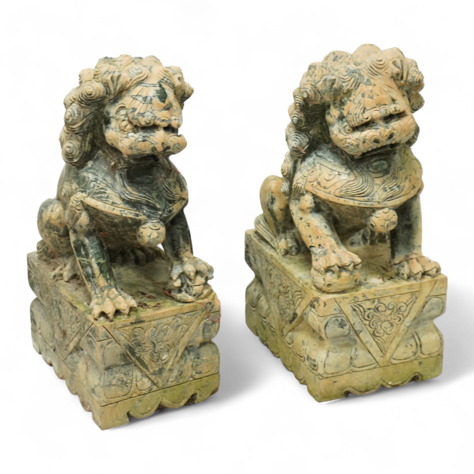 Pair of Chinese hardstone carved Foo dogs, each finely carved seated on rectangular plinth bases with detailed manes, collars and bells, the male with paw resting on a ball, the female with cub, in mottled green stone resembling jade