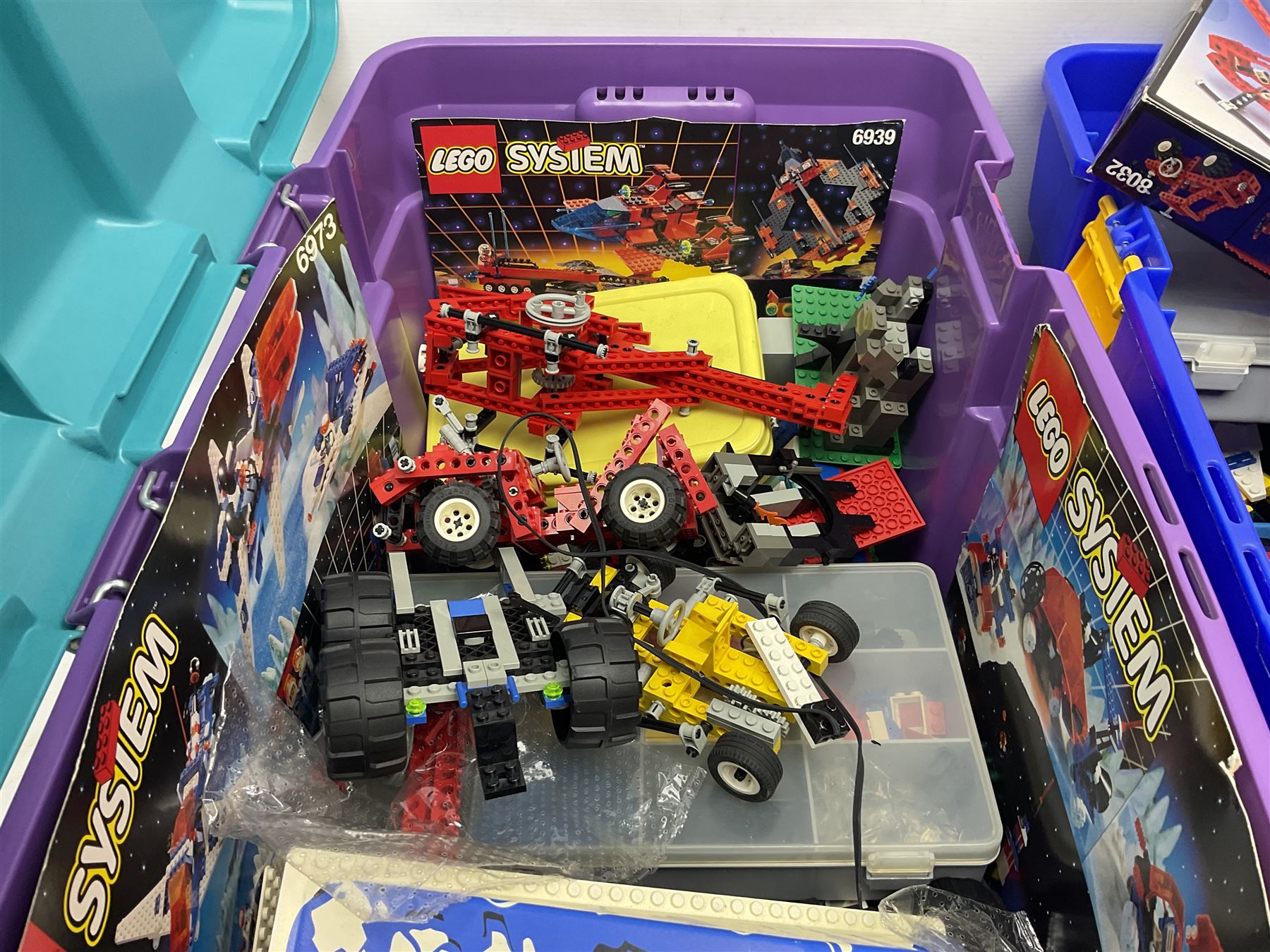 Lego - large quantity of part-built models and loose component parts including Lego Technic and Lego System, space and road vehicles, ships and boats, helicopter etc; together with two set boxes and folder  containing large quantity of instruction booklets; stored in two very large plastic boxes