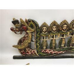Balinese wood wall panel carved as a dragon boat with passengers, painted in reds and greens with gilding, together with a carved wood figure of Ganesh Deity decorated with gilt, raised upon circular lotus flower plinth, H78cm
