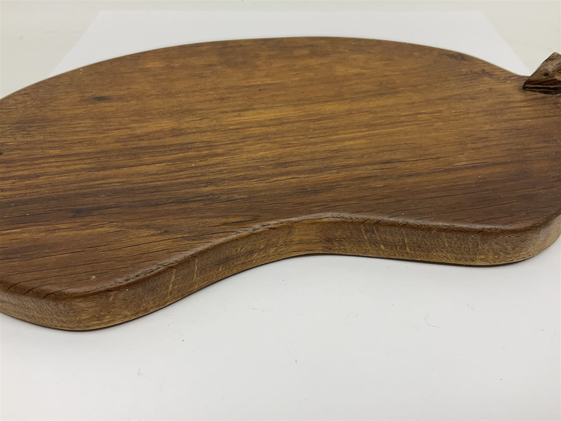 Mouseman - oak kidney-shaped cheeseboard, the handle caved with mouse signature, by the workshop of Robert Thompson, Kilburn 