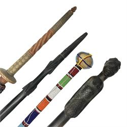 African carved hardwood twisted walking stick with carved figure to the top, together with decorative wooden training sword and two others