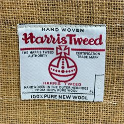 Interiors at Nine to Eleven - Edwardian design armchair, traditional shape with rolled arms, upholstered in 'Harris Tweed' fabric with leather piping, raised on square taping supports with castors