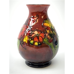 A Moorcroft flambé vase, of baluster form decorated in the Orchid pattern, with impressed mark and Royal Warrant paper label beneath, H15cm.