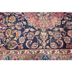 Vintage Persian Tabriz indigo ground rug, the central floral medallion within a field woven with scrolling palmettes and plant motifs, with contrasting spandrels, the the cyan guard lines with scrolling floral patterns