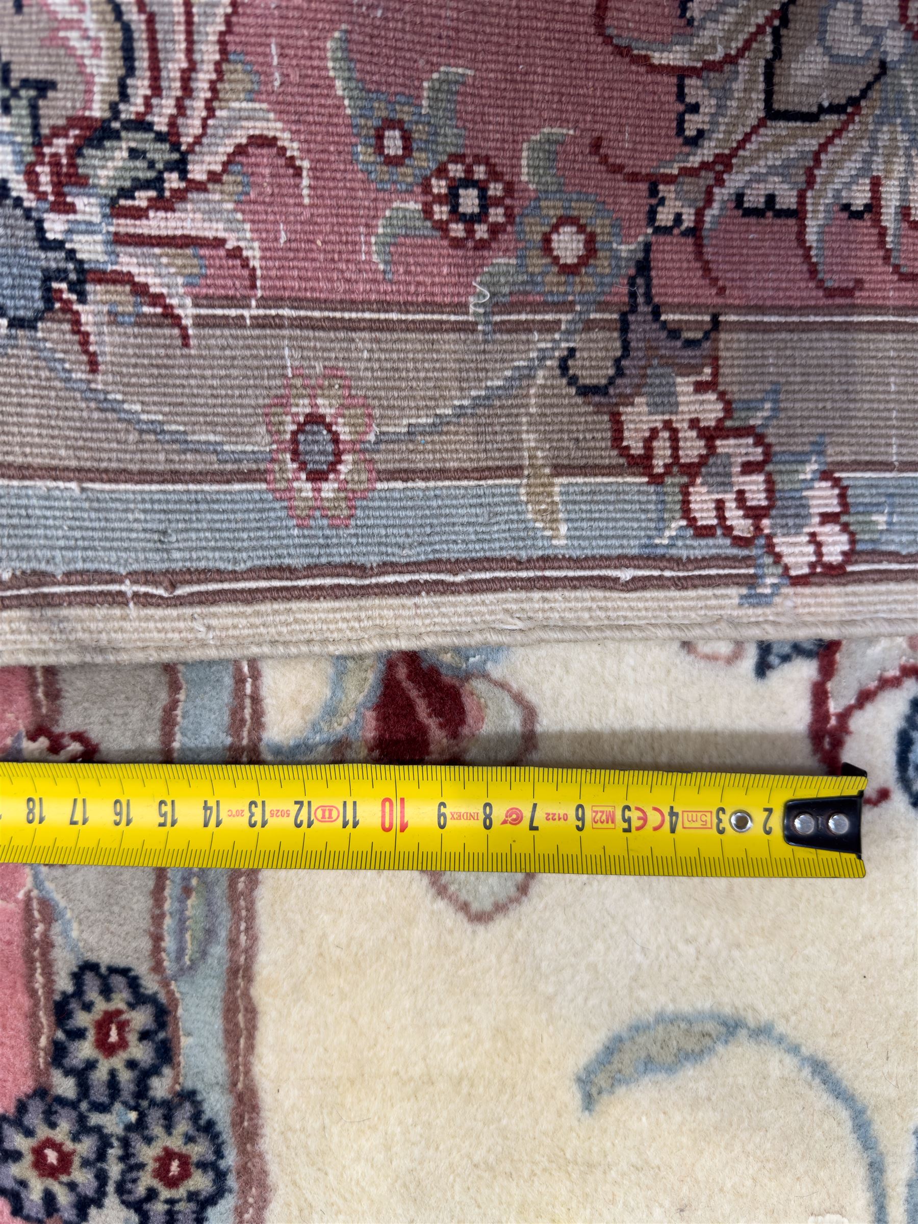 North East Persian Kashmar hand-knotted rug, ivory field with an all-over design of linked floral medallions and scrolling vines with a central circular medallion enclosed by multiple borders and a main broad madder field with palmettes and arabesques, 248cm x 145cm