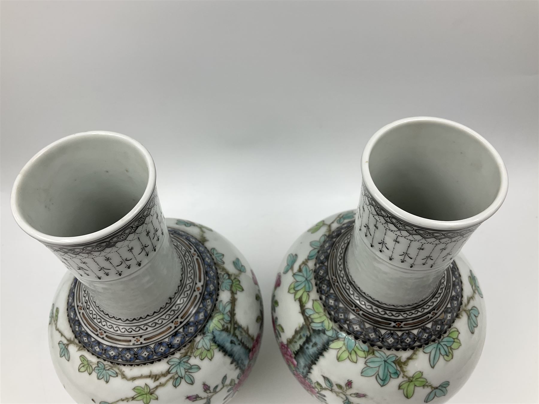 Pair of Chinese Republic porcelain vases, each painted in Famille Rose enamels with pairs of pigeons amidst peony, rock, flowering plants and leafy branches, possibly Qianlong seal beneath, H22cm 