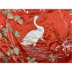 Chinese silk throw, embroidered with wading cranes amongst flowers, branches and leaves upon a red ground, with plaited border and tassel to each corner, L226cm , W176cm