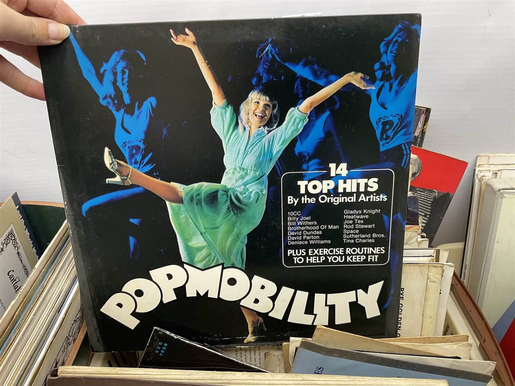 Wooden magazine rack, with floral detail, together with a collection of records, to include the box sets 'the Story of Great Music', 'Popmobility', Happy Holiday in Greece  etc, in three boxes 