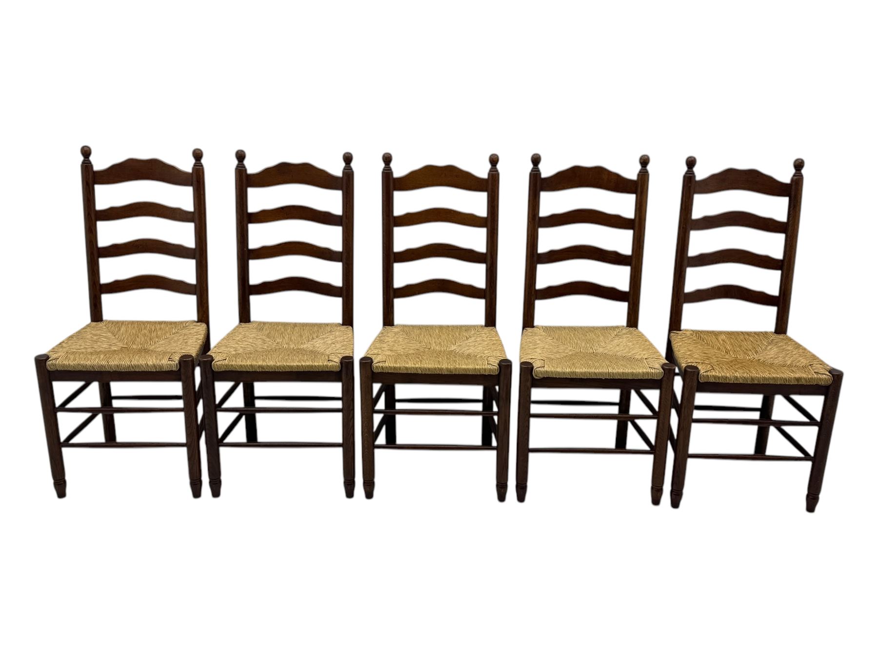 Set of ten 18th century design oak ladder back dining chairs, shaped cresting rail over four horizontal splats, rush seat raised on turned supports united by double stretchers