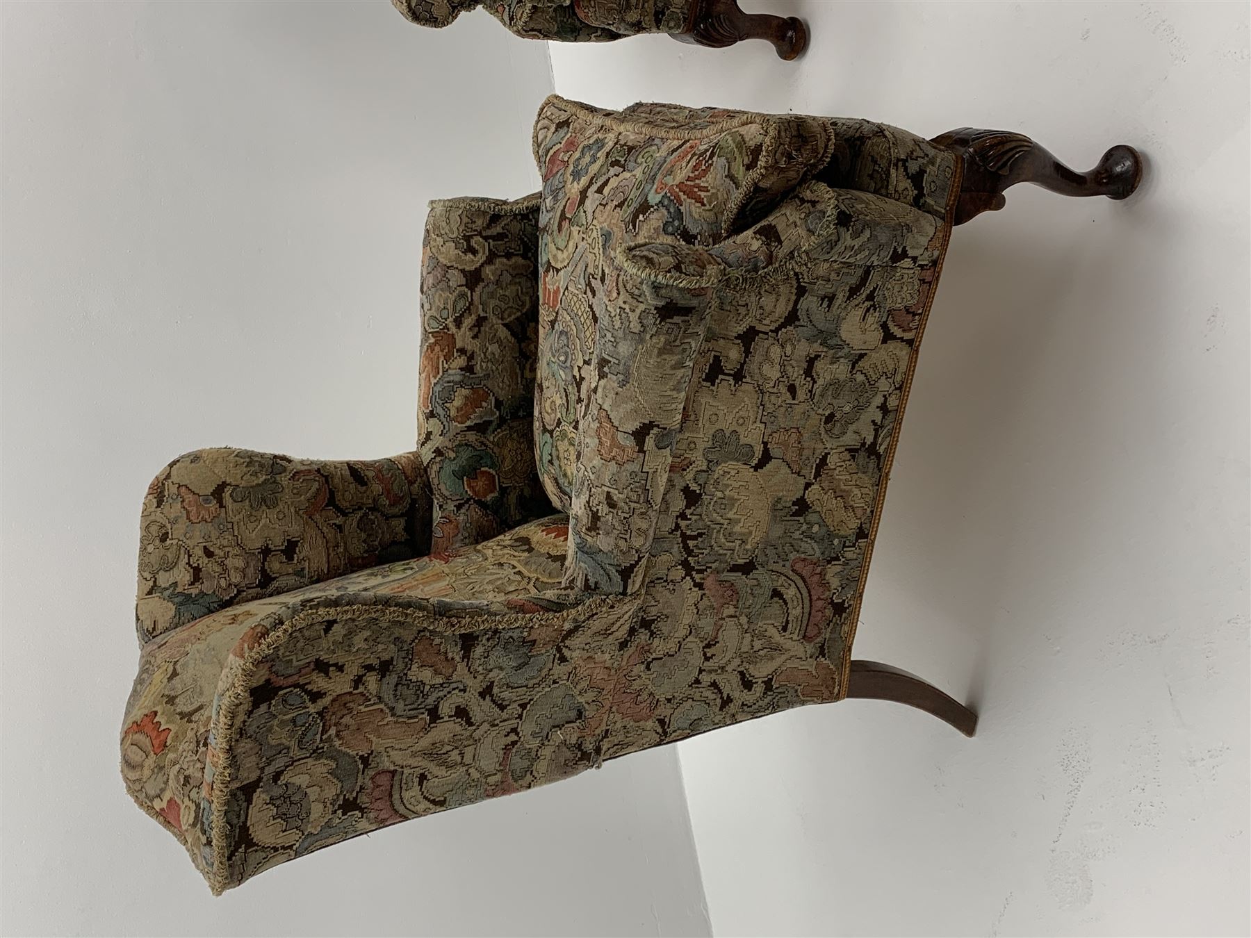 Matched pair early 20th century Queen Anne style wingback armchairs, walnut framed, sprung seats with seat cushions upholstered in needle work cover, shell carved cabriole front feet