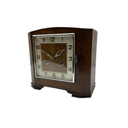 A 1930’S Art Deco 8-day striking mantle clock in a rectangular oak case on raised feet, with a corresponding square dial, hours in Arabic numerals and minute track, with pierced silvered hands, chrome winding collets and a square chrome bezel, striking the hours and half-hours on a coiled gong. 
With pendulum.

