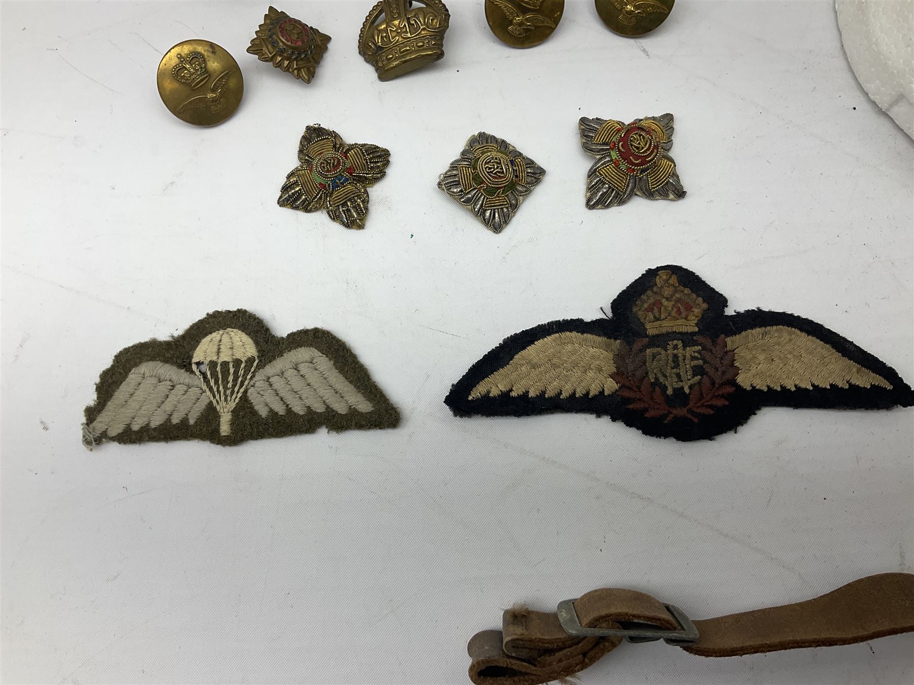 WW2 RAF sidecap dated 1942 with badge and buttons; quantity of RAF metal and cloth badges, pips and buttons; and paratrooper's helmet chin strap