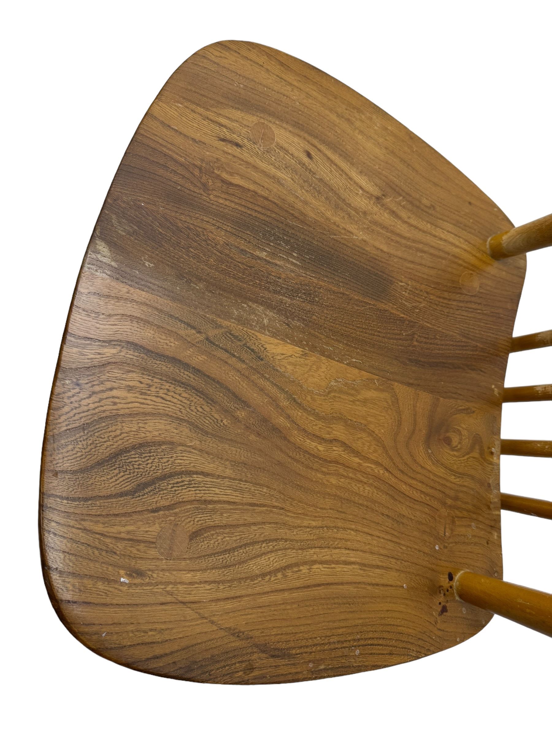 Ercol - pair of mid-20th century highback 'Windsor' chairs, curved top rail over six vertical spindles and shaped seat, on tapering cylindrical supports with stretchers