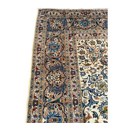 Persian Kashan ivory ground carpet, the interlaced foliate medallion surrounded by trailing plant motifs interlaced with scrolls, the guarded border with repeating stylised flower heads