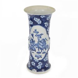 Late 19th century Chinese blue and white gu beaker vase, decorated with two lobed reserves containing precious objects, against a prunus and cracked ice ground, with apocryphal Kangxi mark beneath, H30.5cm