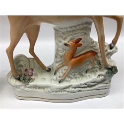 Group of 19th century Staffordshire figures, to include spill vase modelled with doe raising one fore leg above fawn against tree stump, flatback Zebra figure with front leg raised, figure of a recumbent sheep on a mound base before pink flowering bocage, pair of later seated cats on cushions etc, tallest example H29cm