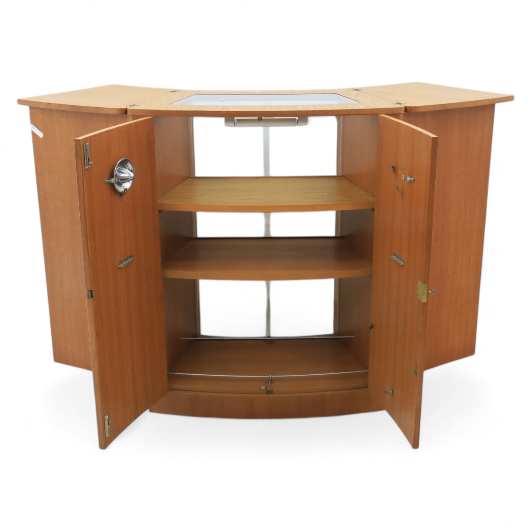 Turnbridge of London - Mid 20th century teak cocktail cabinet, with fold out top extending to 160cm, with twin doors revealing a shelved interior, the back with sliding glazed doors, raised on a recessed plinth base with castors