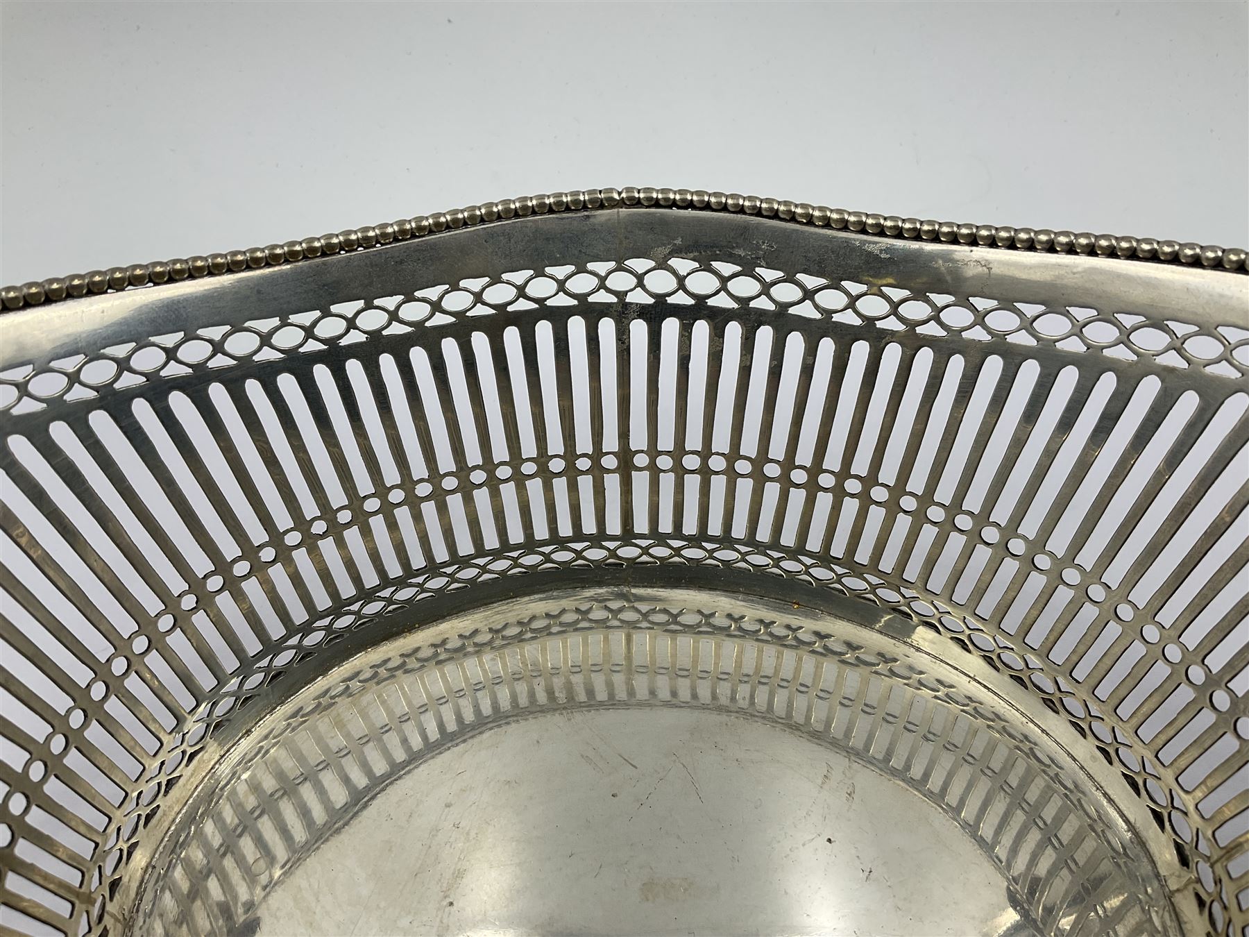 Early 20th century Dutch silver basket, of oval form with pierced sides, beaded rim, and twin handles, marked with Lion Passant for 2nd standard purity and date letter for 1910, other marks worn and indistinct, including handles H8.5cm L25.5cm
