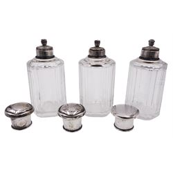 Set of three German silver mounted glass dressing table jars, each of cylindrical faceted form, with internal stoppers and silver covers (two matching), with crown and crescent mark and makers mark for Hermann Bauer, and stamped 800, each approximately H13cm