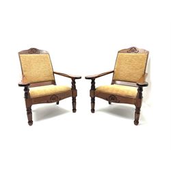 Pair hardwood framed plantation chairs, shaped and carved cresting rail, turned supports, upholstered and studded back and seat