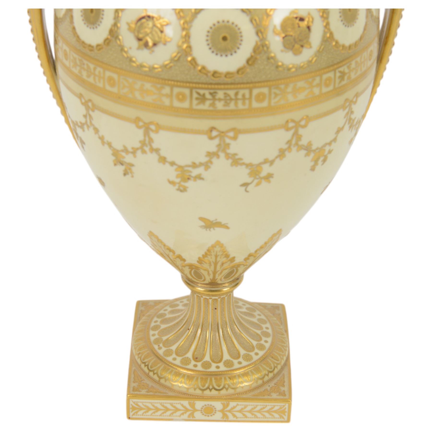 Royal Crown Derby twin handled vase and cover, circa 1886, decorated with raised and tooled gilt borders of foliate scrolls and husk swags upon a cream ground, H38cm