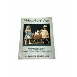 Heidi Ott doll in tartan dress, navy floral dress with white lace and ribbon detailing, striped blue and white dress and a 'Head to Toe' book