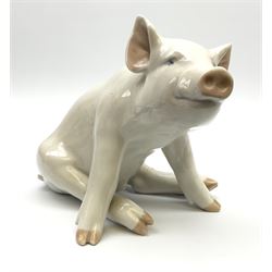 A Royal Copenhagen figure modelled as a seated pig 414, H16cm