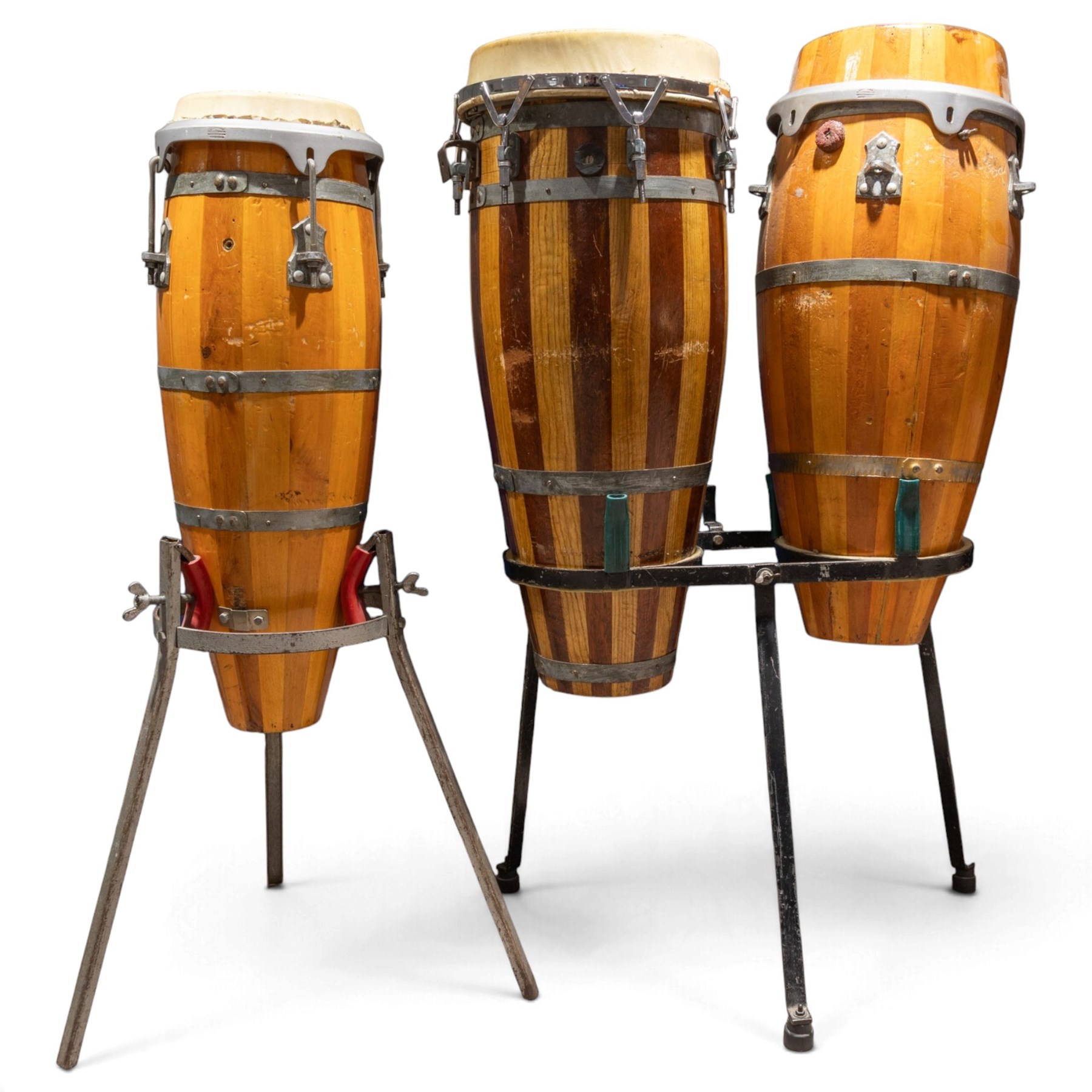 Three conga drums, comprising two Excelsior A. Salvadori Firenze stave-built wooden congas and one similar French example, with skin heads and metal tension mounts, on metal stands with hard carry cases for drums, tallest H79cm, D31cm