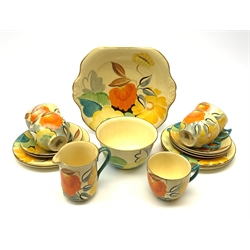 A Grays Pottery tea set, hand painted with flowers in tones of orange, yellow and green, comprising five tea cups and five saucers, five side plates, milk jug, open sucrier, and sandwich plate. 