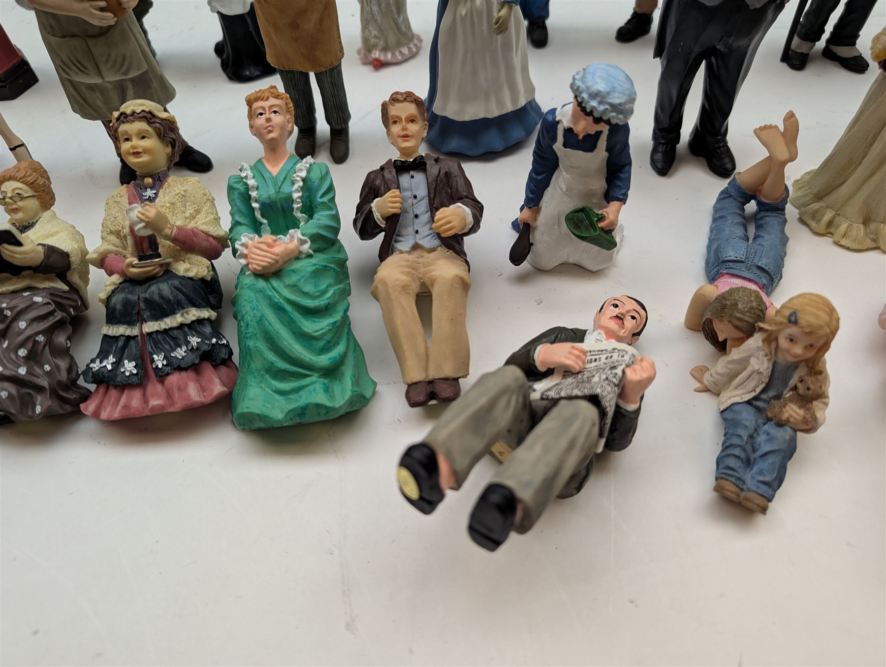 1:12 scale dolls house composite figures, including policeman, postman, maid, sitting and standing people in various styles of dress, etc