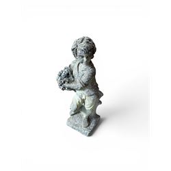 Weathered cast stone garden figure depicting a child holding a fruit basket