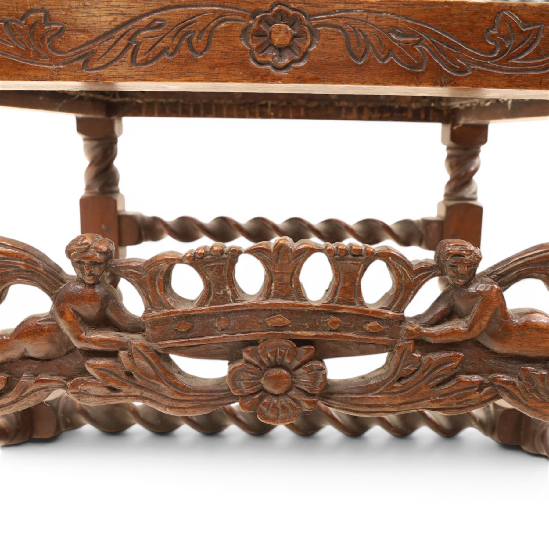 Late Victorian Jacobean Revival oak armchair, the caned back within a pierced and carved foliate frame surmounted by acorn finials, carved scroll arm supports, caned seat, on barley twist supports united by stretchers and carved front rail