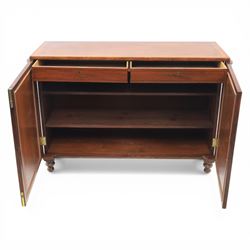 Late 20th century Regency style mahogany side cabinet, the rectangular crossbanded top with ebonised line inlay, above a pair of brass lattice grille doors with pale green fabric backing enclosing a shelved interior and two frieze drawers, flanked by reeded corner pilasters, upon turned tapering feet