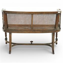 20th century bergère two seater settee, with shaped curved top rail and downswept arms, the back and seat fitted with woven cane panels, supported by turned uprights and legs united by a carolean stretcher 