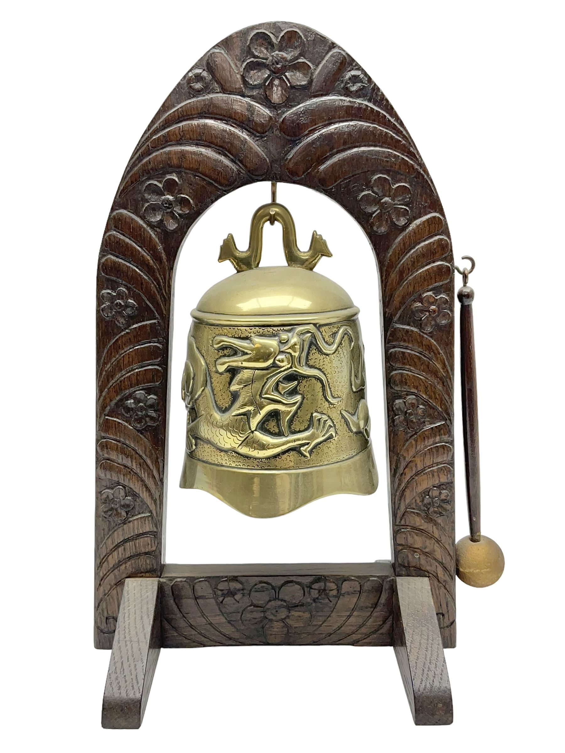 Chinese brass temple bell, decorated in high relief with a a dragon chasing a flaming pearl, within a carved floral hardwood stand, H36cm