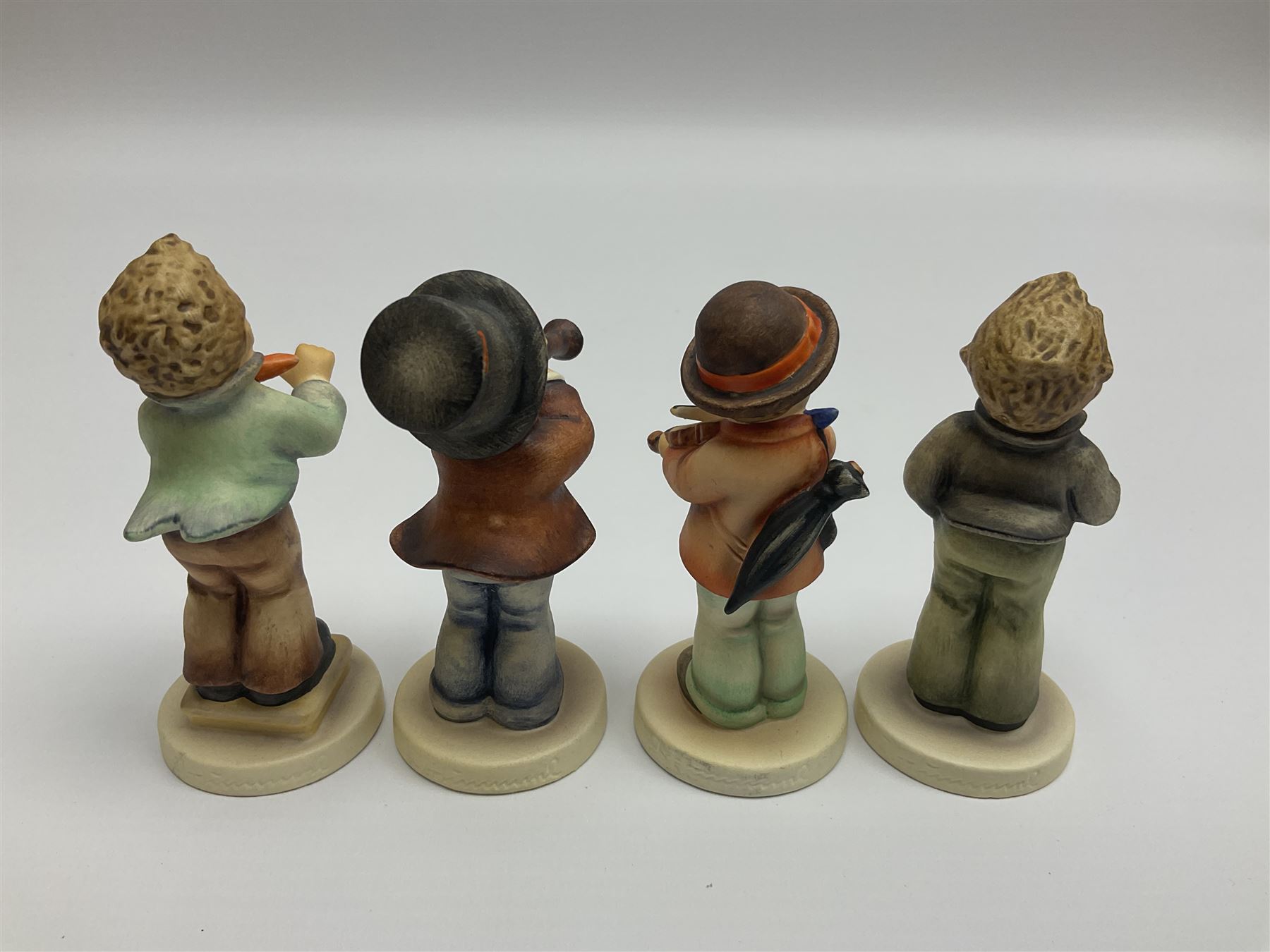 Thirty Hummel figures by Goebel, to include Saluting the Peacekeepers of Operation Joint Endeavor, on wooden plinth, Call to Glory, Celebrate with Song and Soldier Boy