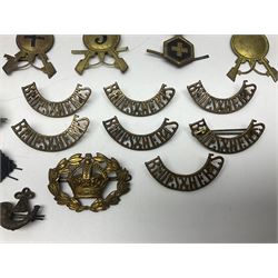 Over thirty British and Continental military metal badges; together with quantity of shoulder titles, collar dogs, rank pips, uniform buttons etc