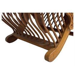 Early 20th century carved teak Howdah elephant chair, with pierced floral and foliate carved backrest, spindle gallery arm supports, cream upholstered cushions, splayed legs on a curved reeded base 