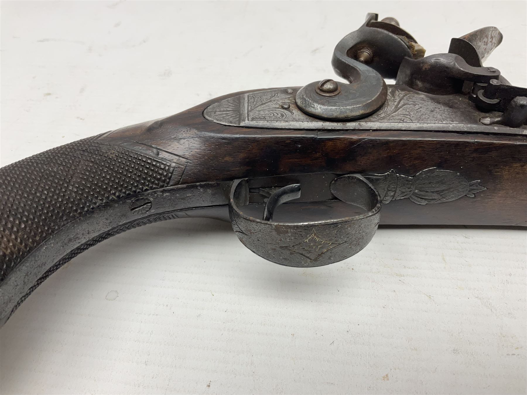 Early 19th century 16-bore flintlock single barrel travelling pistol, the 21.5cm stub twist octagonal barrel with two barrel pins and ramrod under, engraved lock plate with roller frizzen, engraved trigger guard with pineapple finial, walnut stoock with chequered grip L40cm overall