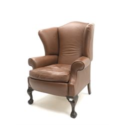 Georgian style high wing back armchair, upholstered in tan leather, mahogany legs with ball and claw feet