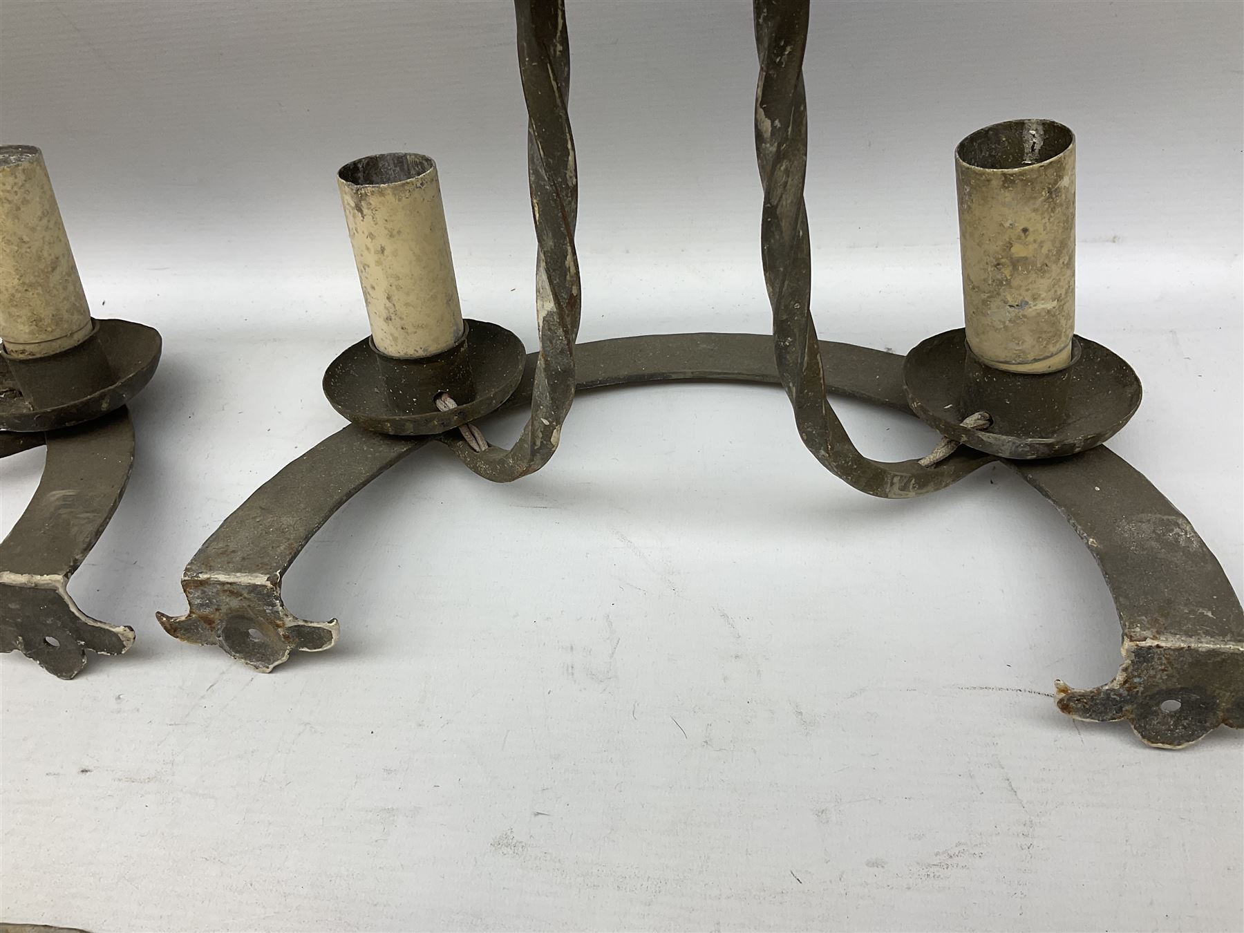 Gothic style iron chandelier with drip pans and twisted branches together with three matching twin wall sconces